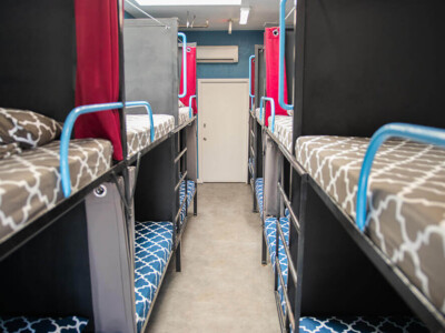 Shared dorm room with bunk beds and lockers at California Dreams Hostel