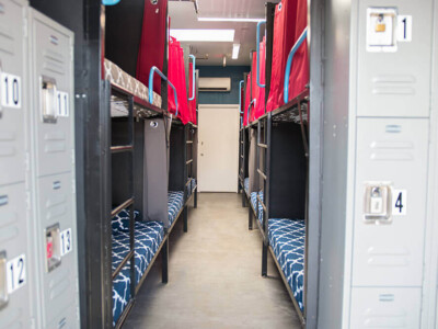 Shared dorm room with bunk beds and lockers at California Dreams Hostel in San Diego