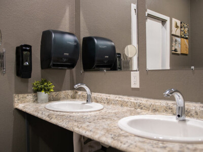 Clean hostel bathroom with double sinks and mirrors at California Dreams Hostel