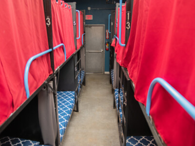 Shared dorm room with bunk beds and privacy curtains at California Dreams Hostel