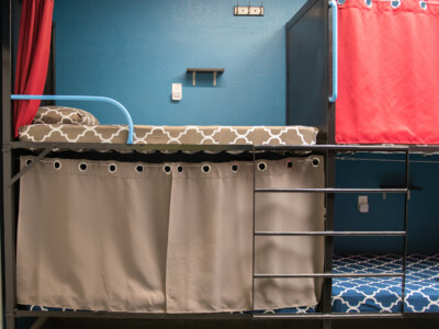 Bunk beds with privacy curtains and personal outlets at California Dreams Hostel