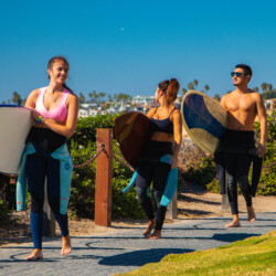 Travelers carrying surfboards near the beach in San Diego