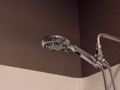 Modern showerhead in a clean private shower at California Dreams Hostel